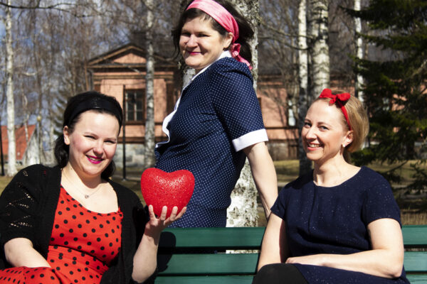 Kolme näyttelijää poseeraa kameralle 60-luvulle tyypillisissä vaatteissa